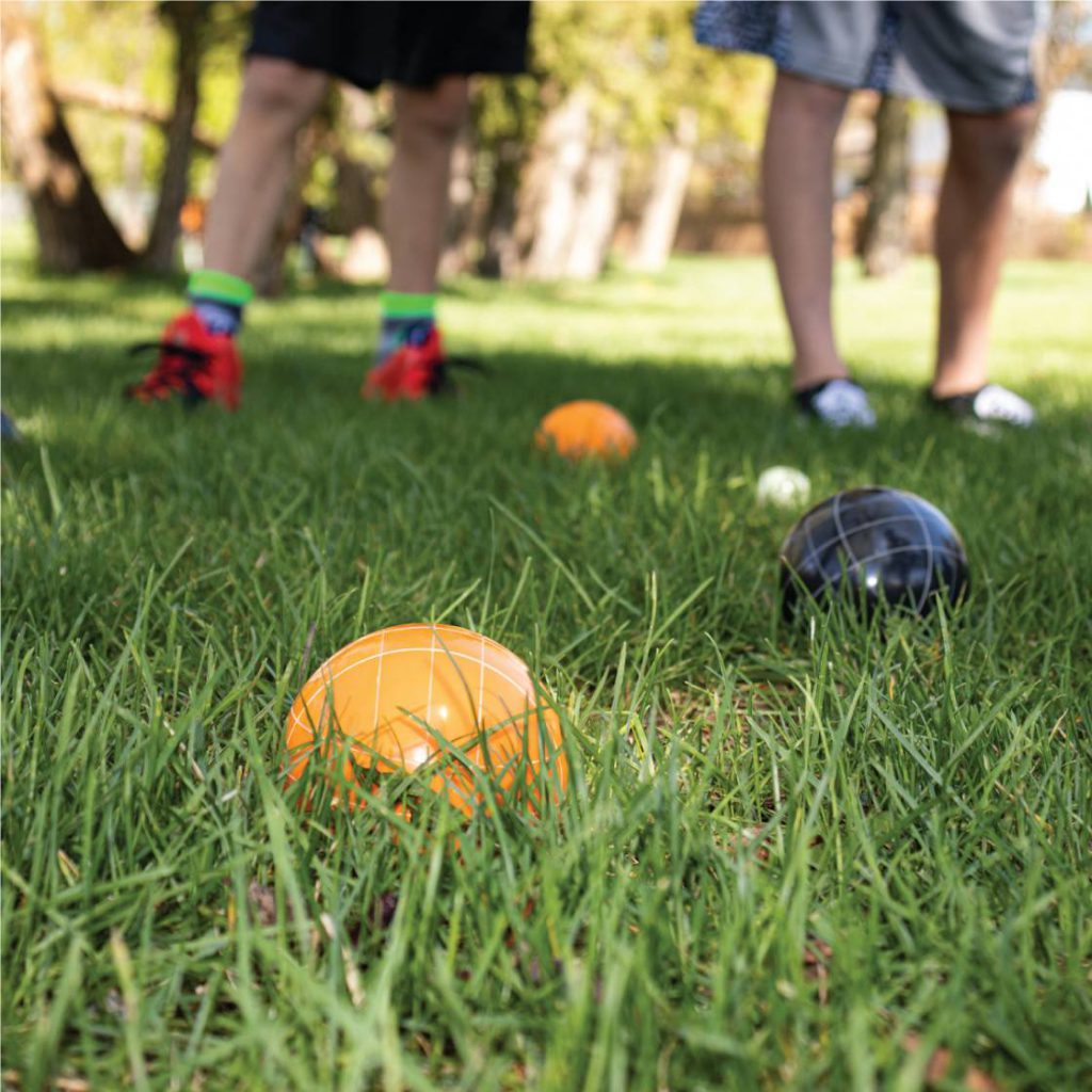 Guide to playing bocce in a backyard with balls and pallino on grass