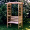 Summer Cedar A tranquil wooden garden swing beneath a blossoming arch, set against a backdrop of lush greenery on Summer Cedar. summercedar.com