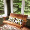 Summer Cedar A cozy cedar porch swing with patterned cushions awaits someone to sit and enjoy the serene forest view. summercedar.com