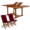 Summer Cedar An extendable wooden dining table with its leaves partly open, paired with two matching folding chairs from Summer Cedar, featuring red cushions. summercedar.com