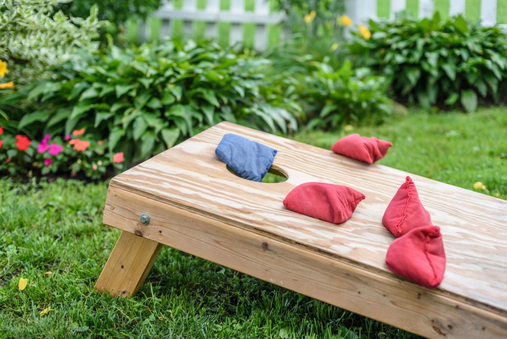 Guide to playing cornhole in a backyard with boards, bean bags, and outdoor seating